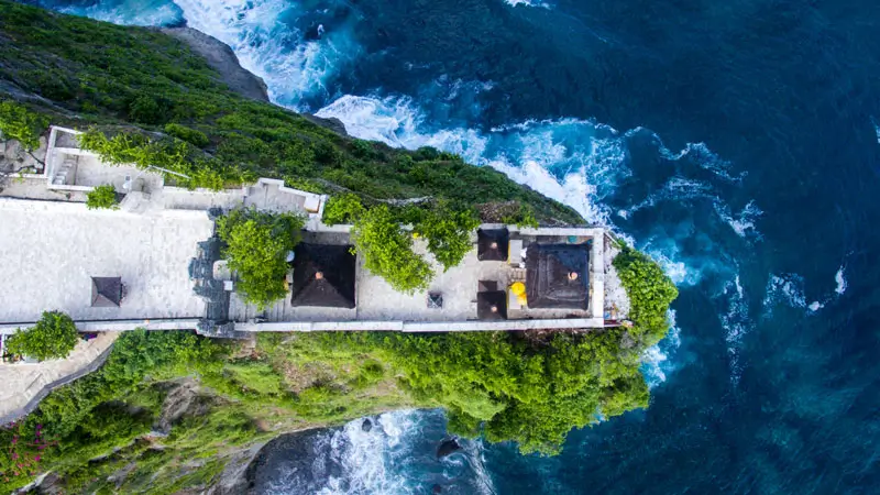 Aerial view of Uluwatu Temple perched on a cliff with the ocean below in Bali, Indonesia.