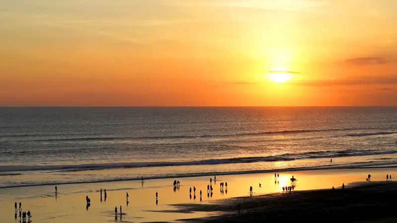 Sunset at Seminyak Beach Bali with silhouettes of visitors