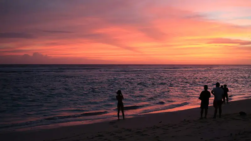 Visitors observe the spectacular sunset at Melasti Beach Ungasan