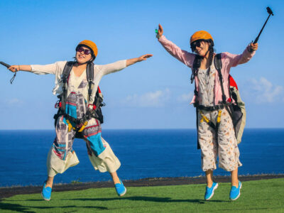 Group of young adults enjoying unforgettable activities in Bali, such as Bali Paragliding Riug Cliff Uluwatu.