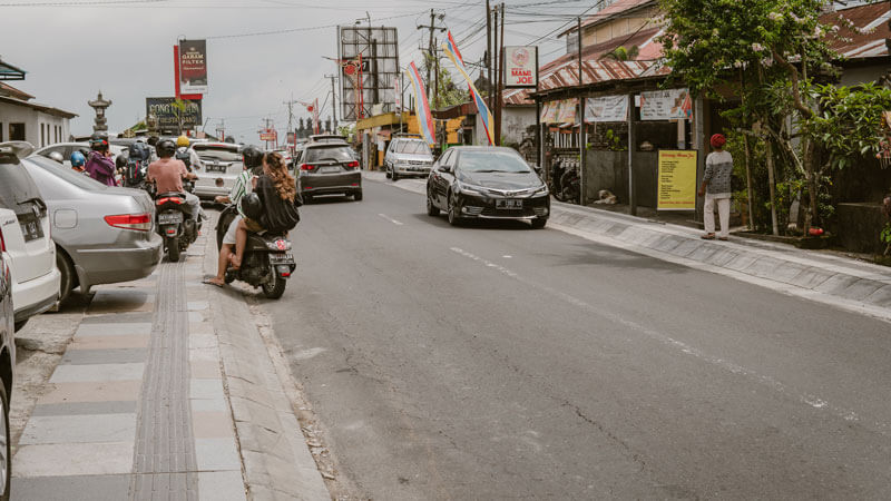 Busy street scene in Kintamani with cars and scooters