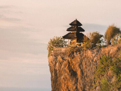 The serene Uluwatu Temple, Bali, perched on a cliff at sunset, overlooking the Indian Ocean.