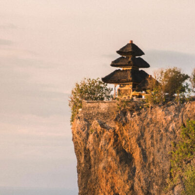 The serene Uluwatu Temple, Bali, perched on a cliff at sunset, overlooking the Indian Ocean.