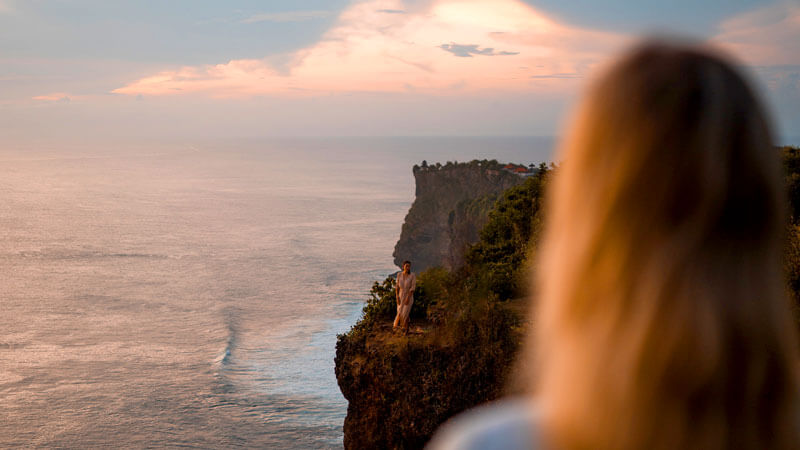 Visitor enjoying the breathtaking sunset view at Uluwatu.