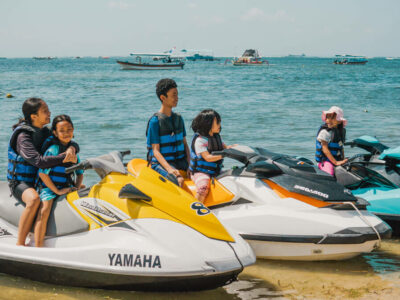 Family with children in life jackets ready for a jet ski ride in Bali