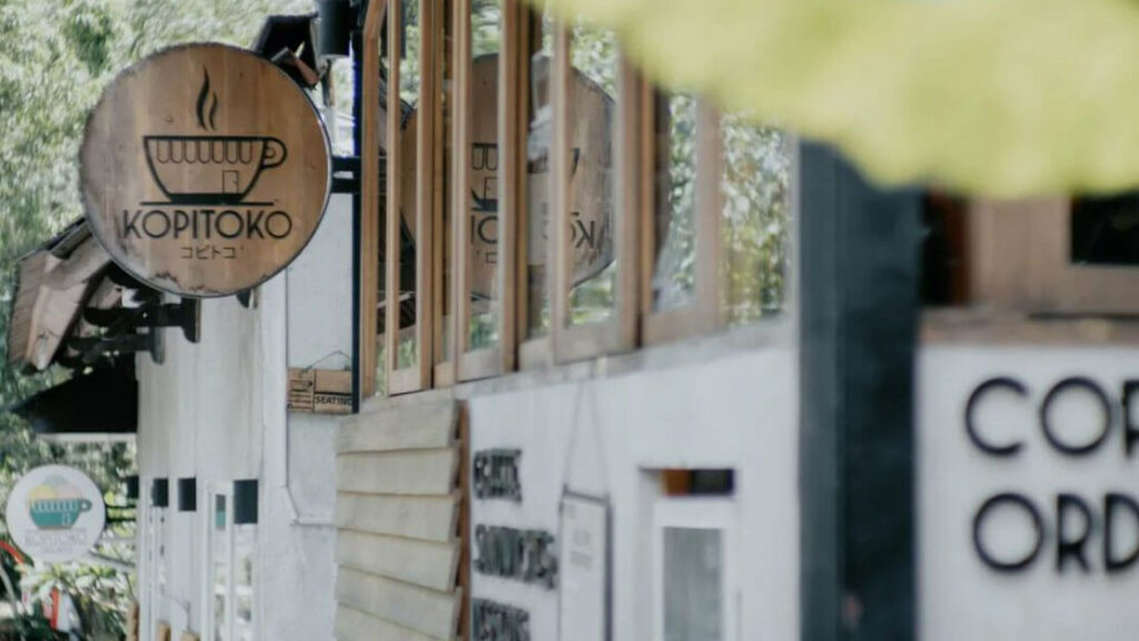 Kopitoko Seminyak sign amidst a serene Bali coffee shop setting.