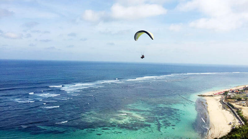 The excitement of paragliding in Bali with sea views.