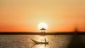 Amazing sunrise at Sanur Beach with fishing boats and Balinese gazebo