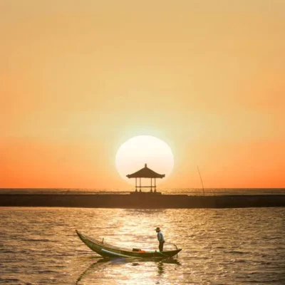 Amazing sunrise at Sanur Beach with fishing boats and Balinese gazebo