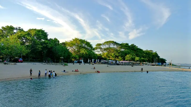 Calm Sanur Beach with visitors enjoying relaxing time for Family-Friendly Vacation