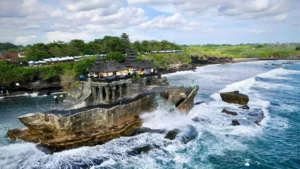 Tanah Lot Temple on Bali coastline with ocean waves crashing against rocks