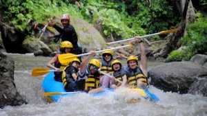 Group of adventurers enjoying a thrilling rafting experience in Bali's lush rivers, showcasing the excitement of adventure tours.