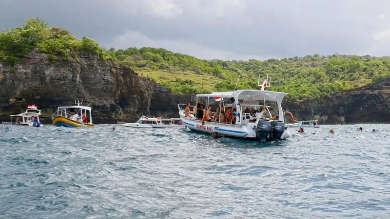 Boats and snorkelers in Bali waters during the dry season