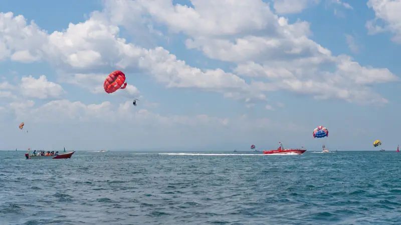 Tourists enjoy parasailing in Tanjung Benoa Bali