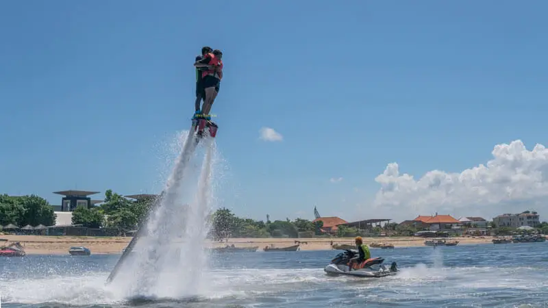 Tourists ride a flyboard in Tanjung Benoa, Bali.