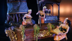 Bali performers in traditional Balinese attire performing the Lesung dance, depicting a cultural rice pounding ritual. Image Credit: © Devdan