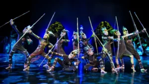 Bali performers in a powerful tribal dance from Papua, wearing traditional costumes and holding spears in synchronized choreography. Image Credit: © Devdan