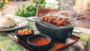 Traditional Balinese chicken satay with rice and sambal on a table