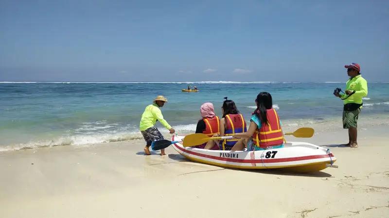 Visitors preparing for canoeing at with clear blue waters.