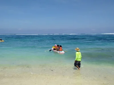 Visitors enjoying canoeing in the turquoise waters of Pandawa Beach Bali.