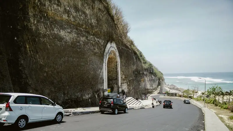 Scenic road flanked by tall limestone cliffs leading to the Beach.