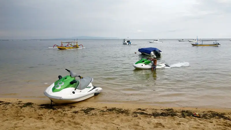 Jet skis and traditional boats on the calm waters of Sanur Waterfront.