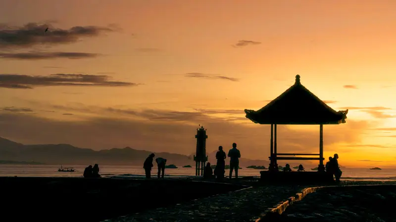 Sunrise at Sanur Seaside with a traditional gazebo silhouette and scenic views.